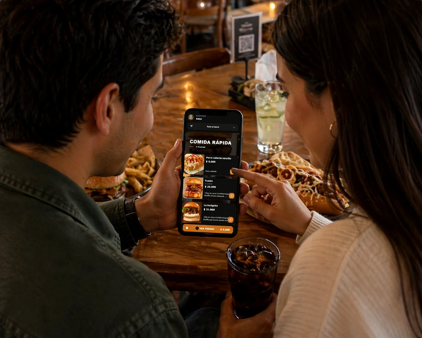 Personas ordenando felizmente desde la app de eatery en un restaurante